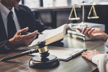 Justice reading from a book with gavel on her desk